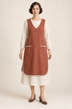 AI design illustration of a terracotta 1920s V-neck tabard apron with ivory binding and rounded front hem over a cream dress