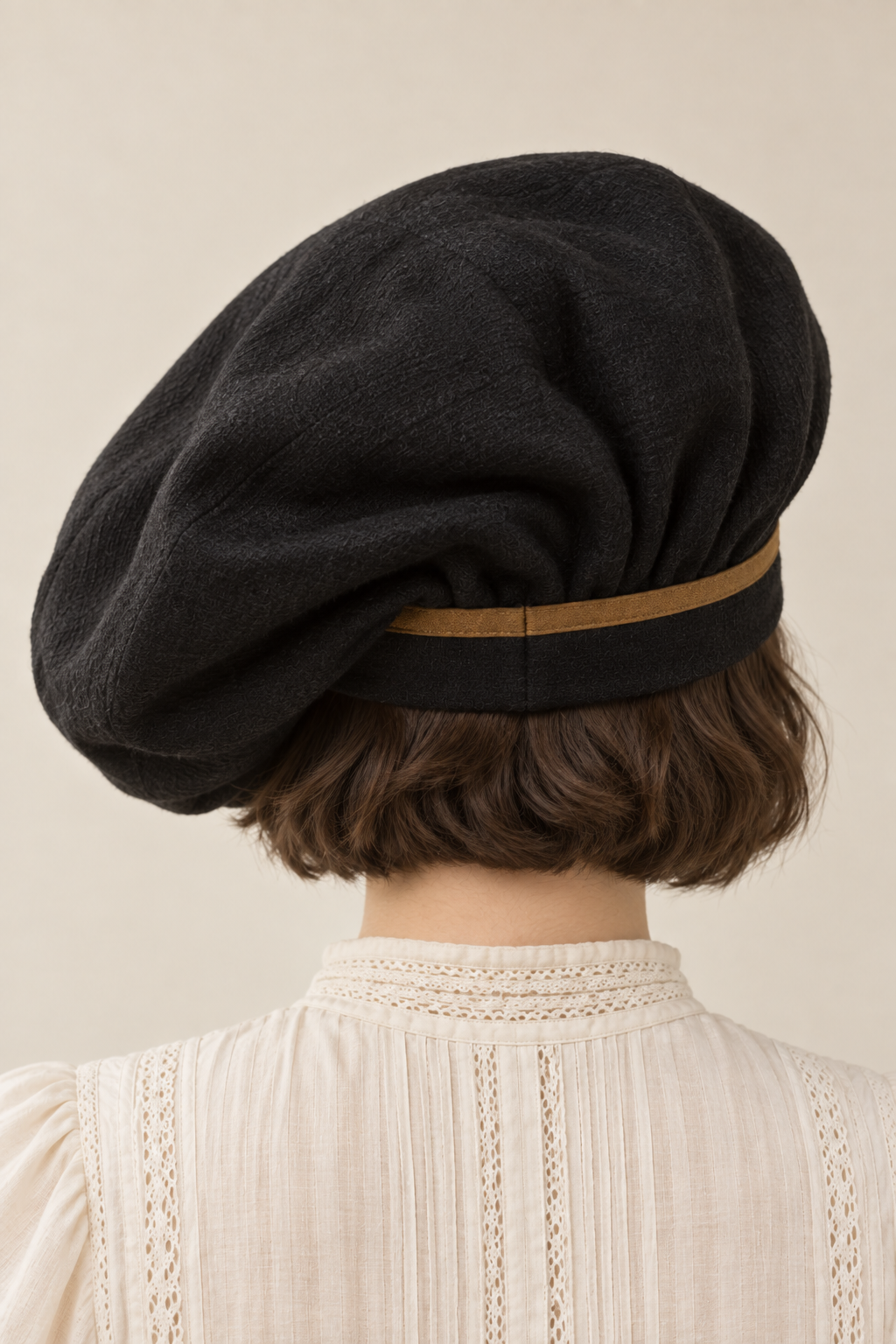 AI design illustration of the black cloth tam from the back, showing crown folds, fitted band and ochre trim