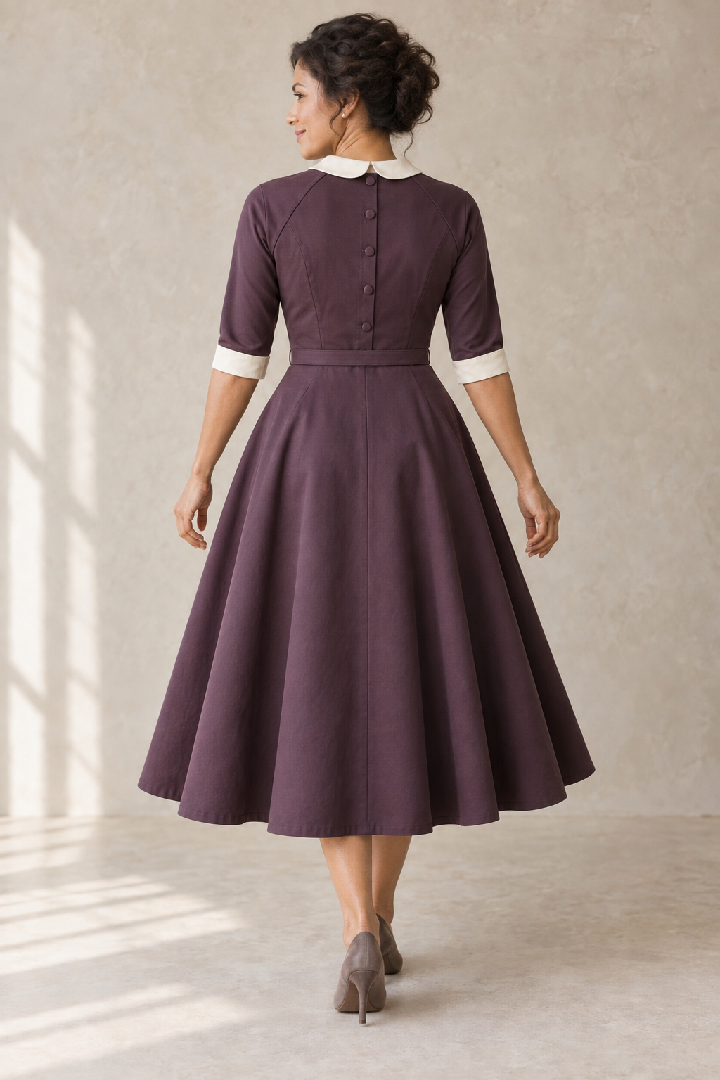 Rear design preview of the same aubergine raglan dress, showing five center-back bodice buttons, raglan joins and ivory cuff bands.