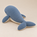 Rear view of the blue whale plush showing its curved body, center seam and broad tail flukes