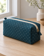 AI design preview: teal dotted boxed zipper pouch, closed three-quarter view showing ivory top zipper, end tab and flat base.