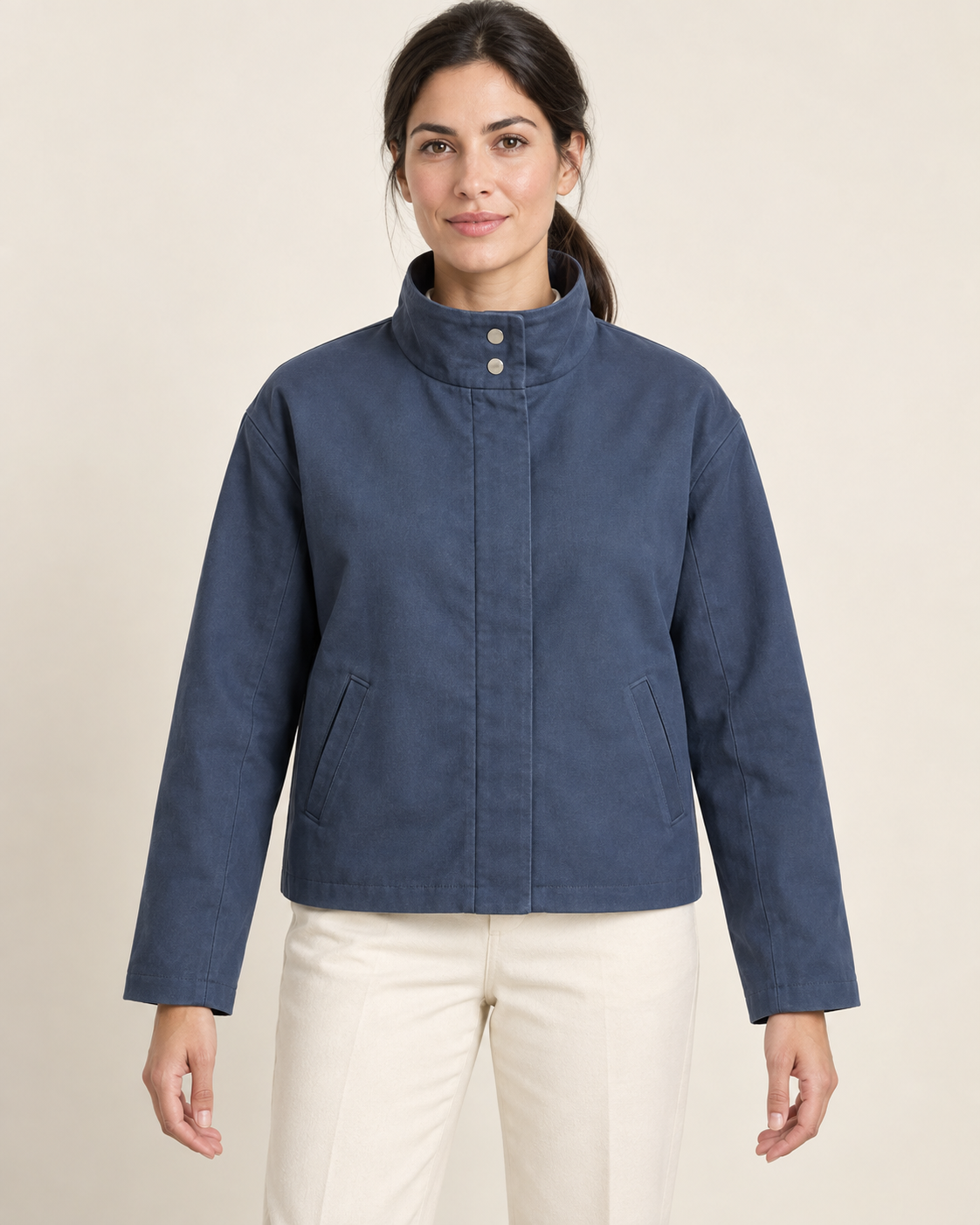 AI design preview: adult woman wearing a blue boxy funnel-neck jacket with two collar snaps, covered zip placket and welt pockets