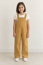 AI design preview: child in ochre bib overalls over ivory T-shirt, showing four strap buttons, chest pocket and curved hip pockets, front view