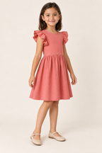 AI design preview: three-quarter view of the coral child dress showing free flutter sleeves and one softly gathered skirt