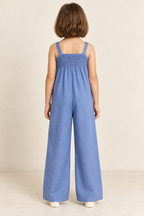 AI design preview: same child and blue jumpsuit showing shirred upper back, fixed straps and plain continuous wide legs without waist seam