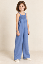 AI design preview: same child in cornflower-blue shirred jumpsuit, three-quarter view showing upper gathering and freely falling body