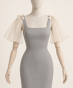 AI design preview: champagne-ivory detachable shoulder cape sleeves with small bows, front view on a gray styling dress.