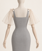 AI design preview: rear of the separate ivory shoulder flounces with an open center back; gray dress is styling only.