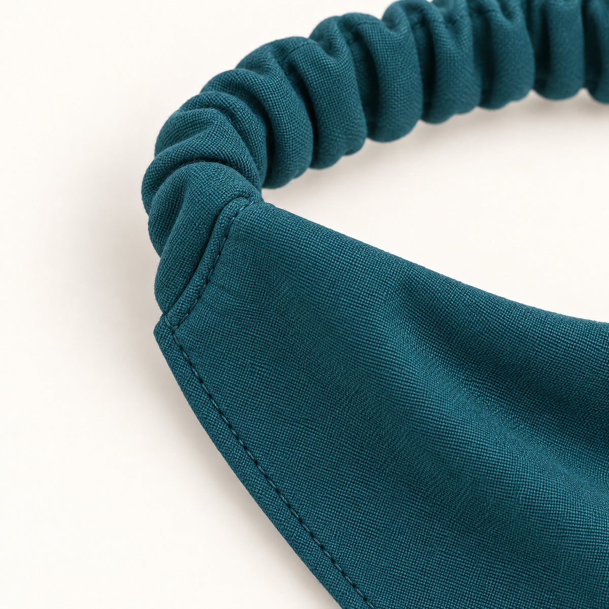 AI design preview: close-up of the petrol-teal dog bandana upper corner where the gathered casing joins the doubled bib