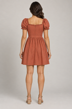 AI design preview: terracotta dress on the same adult woman with smooth square back, waist shaping and concealed center zipper, rear view