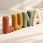 Angled view of padded LUNA fabric letters showing their gusseted sides and stitched edges