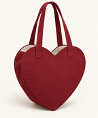 AI design preview: cranberry heart-shaped tote with two handles, ivory lining and visible curved gusset, front three-quarter view.