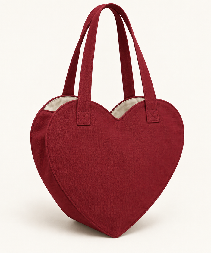 AI design preview: cranberry heart-shaped tote with two handles, ivory lining and visible curved gusset, front three-quarter view.