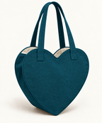 AI design preview: petrol-teal heart tote with the same two handles, shaped open rim and ivory lining.