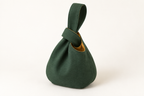AI design preview: forest-green Japanese knot bag with its long closed loop passed through the shorter loop