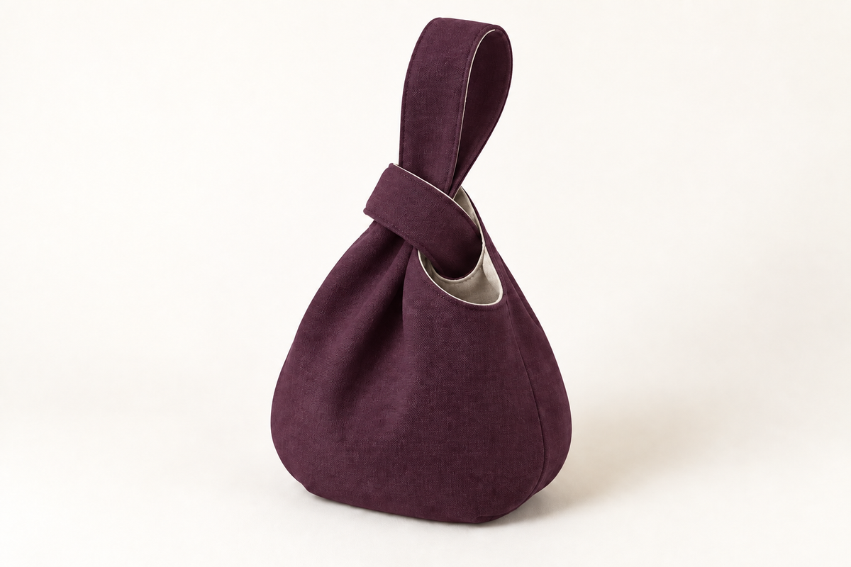 AI design preview: plum and flax color of the same Japanese knot bag with thread-through loop closure
