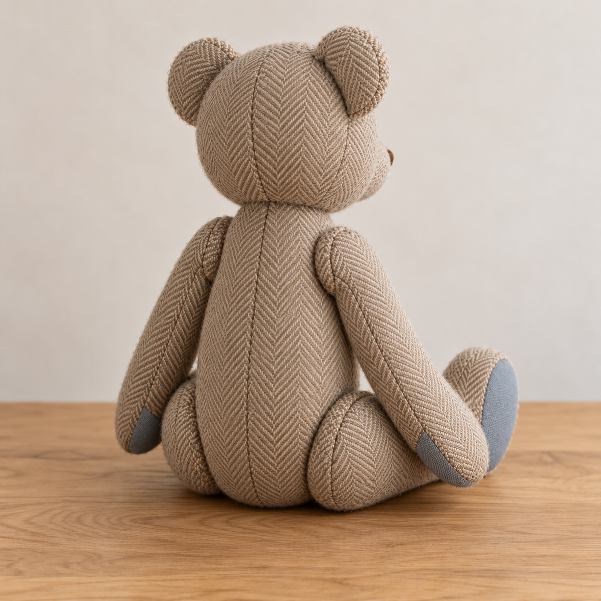 Rear view of the jointed memory teddy bear showing its back seam and articulated limbs