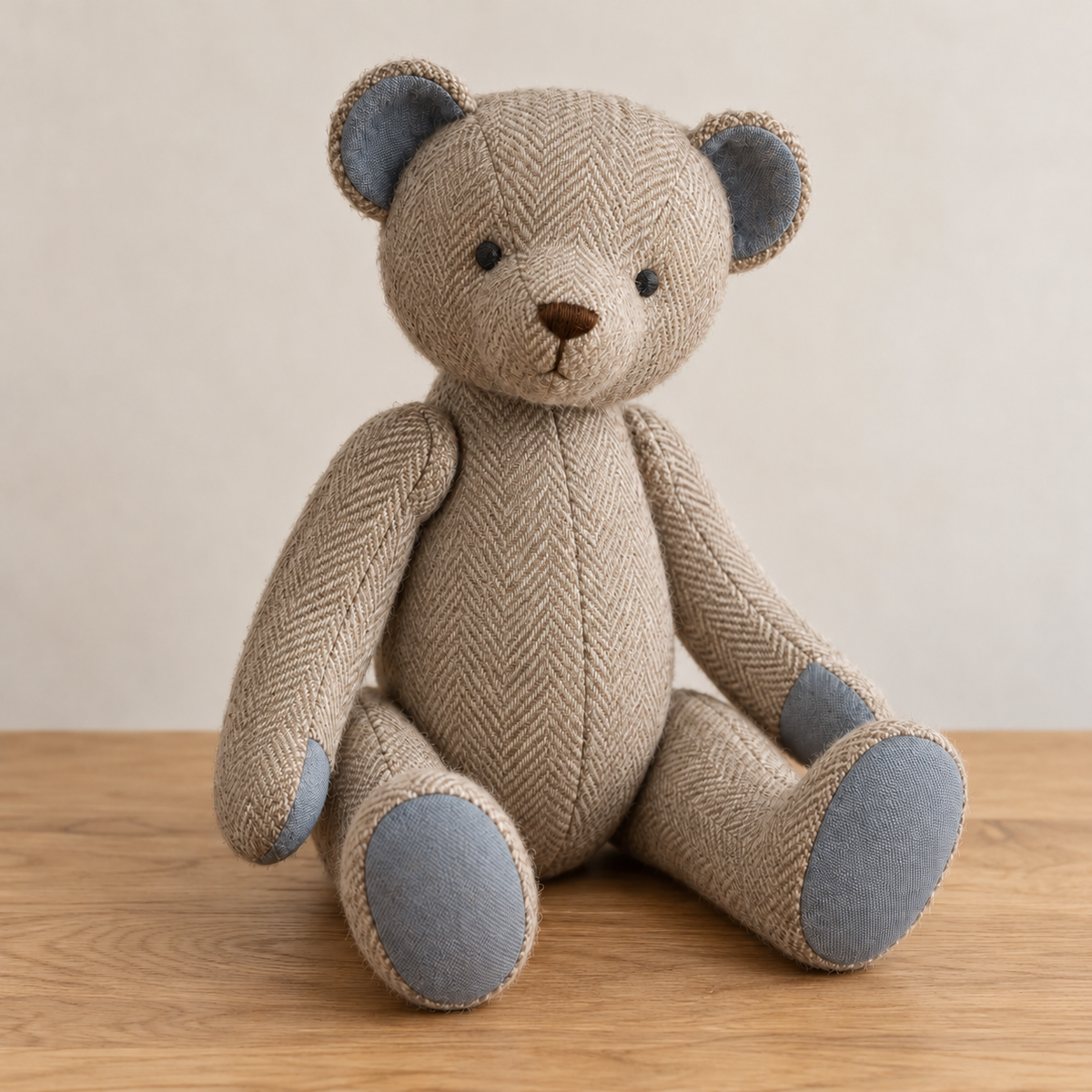 Oatmeal herringbone jointed memory teddy bear with blue cotton paw pads, seated front view