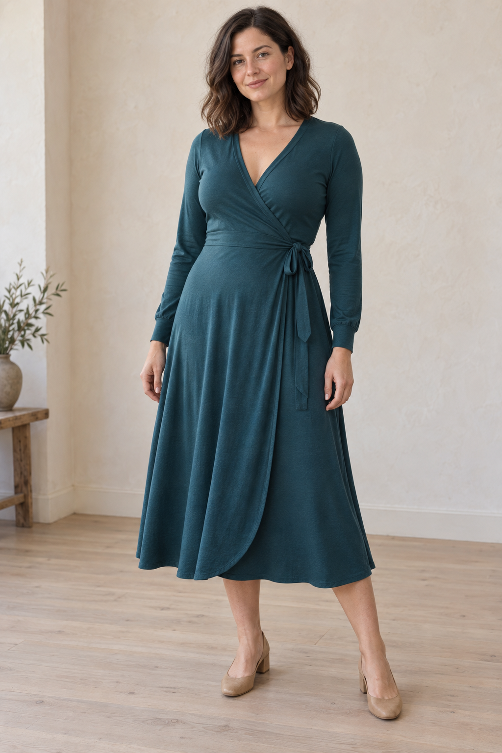 Deep teal knit wrap midi dress design preview on an adult woman, front three-quarter view showing the V-neck band and waist ties.