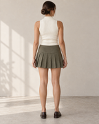Rear design preview of the olive low-rise mini skirt, with a plain contoured yoke and knife pleats continuing around the back