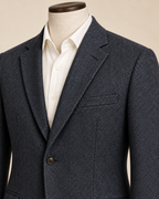 AI concept detail of men's sport coat notched lapel, herringbone texture and welt breast pocket.