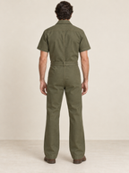 Rear view of olive workwear jumpsuit showing a back yoke and single belt carrier