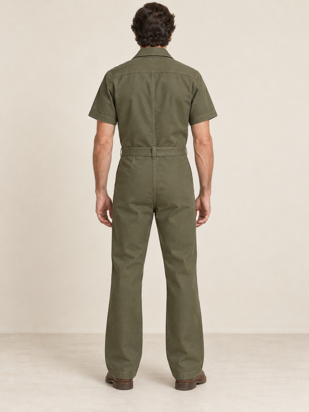 Rear view of olive workwear jumpsuit showing a back yoke and single belt carrier