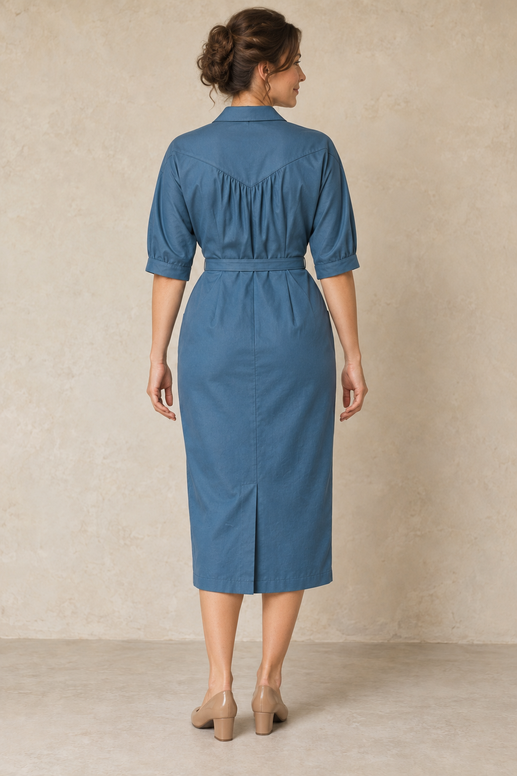 Rear design preview of the same peacock-blue dolman shirt dress, showing the pointed gathered back yoke, cuff bands and skirt kick pleat.