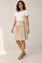 Three-quarter design preview of the same reversible yoke skirt worn with its champagne face outward, showing the wrap overlap and side tie