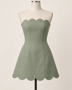AI preview: sage strapless mini dress with curved scalloped neckline and hem and continuous princess panels.