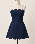 AI preview: midnight-navy color option of the same strapless scalloped mini dress.