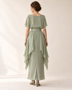 AI design illustration of the celadon draped-hip dress from the back, with a plain bodice and long side drapes