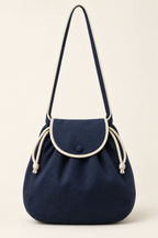 AI front preview of a navy drawstring beach bag with ivory cord, rounded buttoned flap and one long shoulder strap