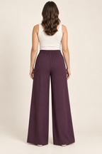AI preview: back of aubergine palazzo pants showing rear-only elastic waistband and plain wide legs.