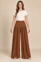 AI preview: copper option of the same fitted hip-yoke palazzo pants with gathered lower legs and plain full-length hems.