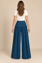 AI preview: back of petrol palazzo pants with a smooth shaped hip yoke and gathered wide legs, without waist elastic or pockets.
