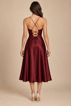 AI preview: rear of wine midi dress with crossed fine straps, fabric-loop lacing and a closed full skirt.