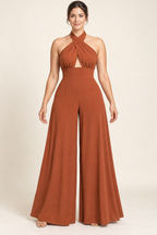 AI design preview: burnt-sienna cross-halter jumpsuit with a small triangular front opening, fitted midriff and flared palazzo legs