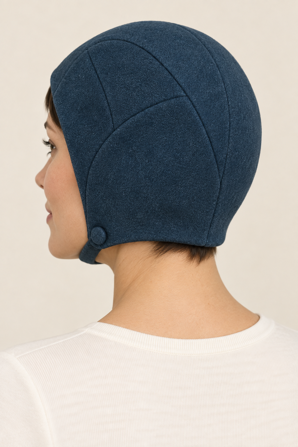 AI design preview: rear three-quarter view of the petrol mod hat showing shaped crown panels, fitted nape and the side chin-strap fastening