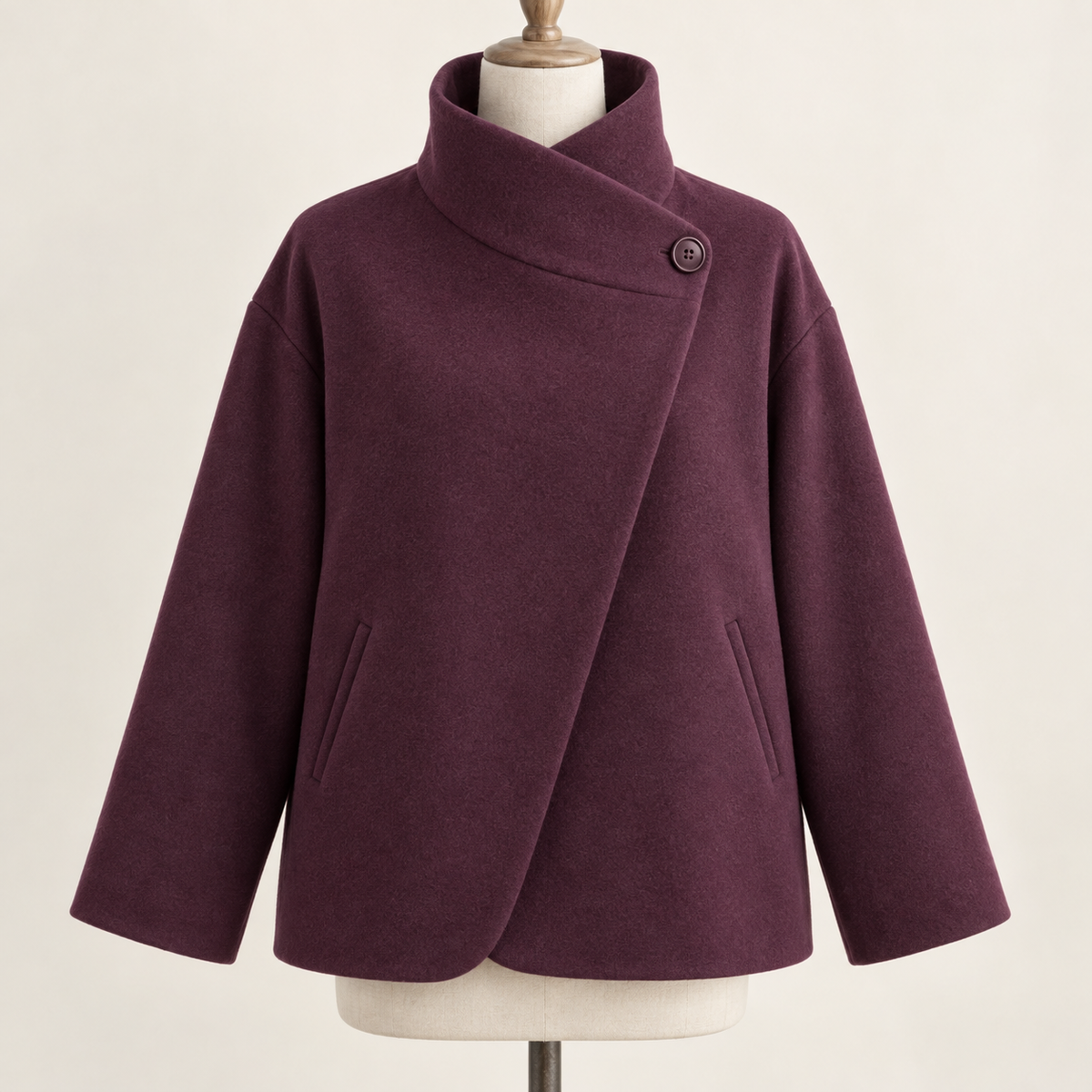 AI design preview: plum asymmetric funnel-neck jacket front with one high side button, diagonal overlap, dropped shoulders and two slanted welt pockets