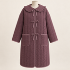 AI design preview: mulberry tie-front quilted coat with three bow closures, a round ruffle-edged collar, dropped sleeves and two patch pockets