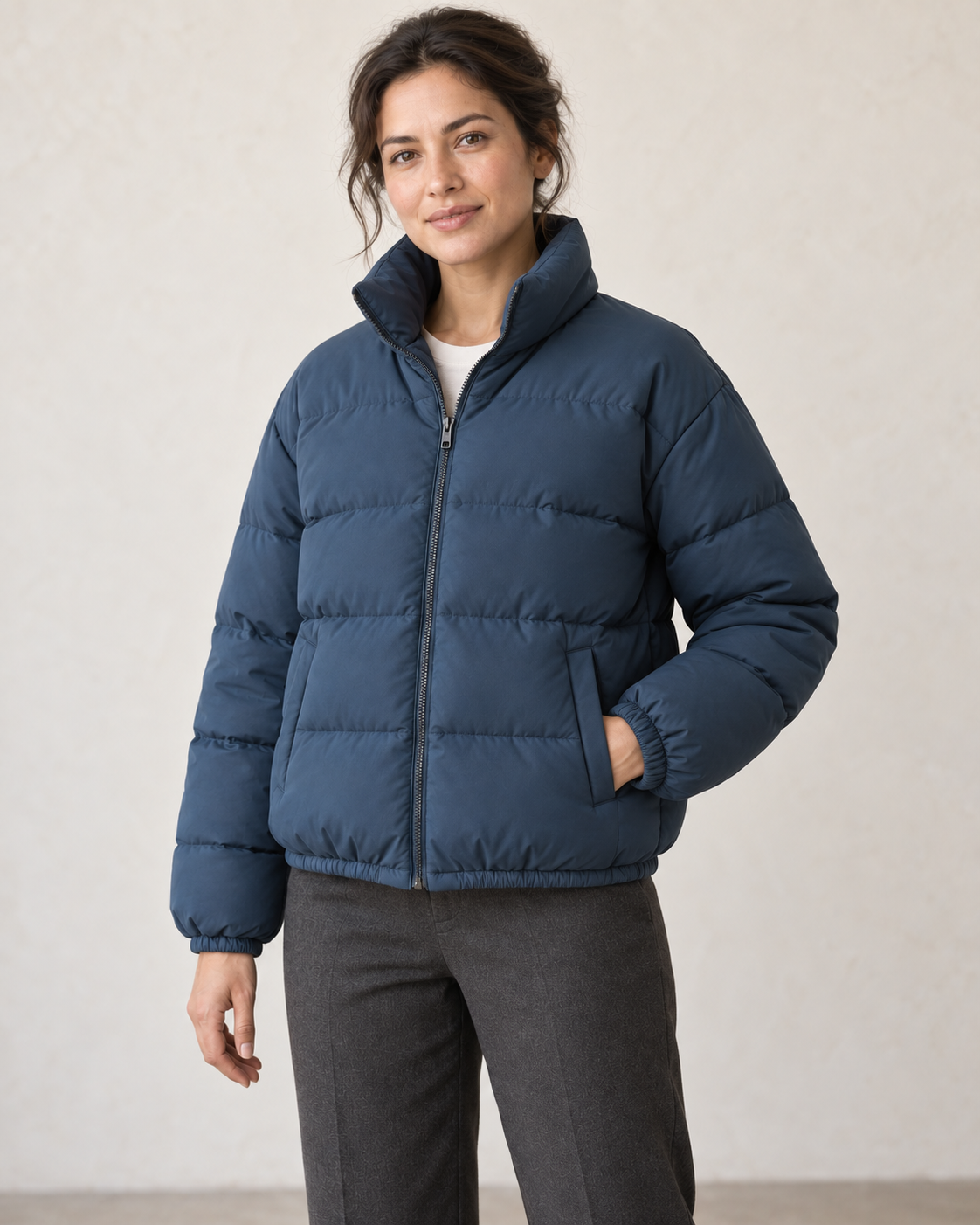 AI design preview: woman wearing a slate-petrol high-collar puffer jacket with front zipper, horizontal padding and welt pockets