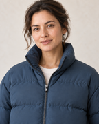 AI design preview: close view of the padded standing collar, zipper and matte woven shell on the same adult female model