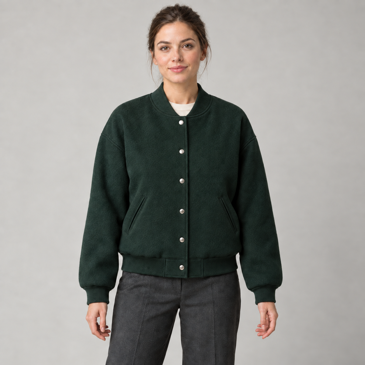 AI design preview: adult woman wearing a forest-green varsity jacket with six front snaps, rib collar and slanted welt pockets