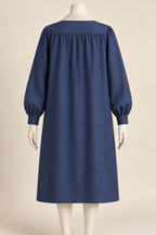 AI design concept: back of indigo smock coat showing shoulder yoke gathers and long cuffed sleeves.