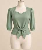 AI front preview of a pale-jade 1940s sweetheart tie-front blouse with three-quarter sleeves