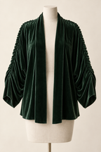 AI design preview: bottle-green velvet shrug with open scarf-like front edges and gathered shoulder-to-sleeve lines.