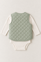Back view of a sage quilted baby vest design laid over a cream bodysuit