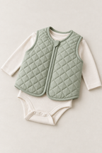 Three-quarter view of a sage quilted baby vest design laid over a cream bodysuit