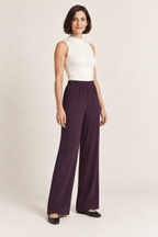 Plum bias-cut wide-leg trousers with an elastic waist, three quarter view on a woman; generated design preview.